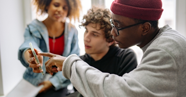Jongeren kijken samen op smartphone.