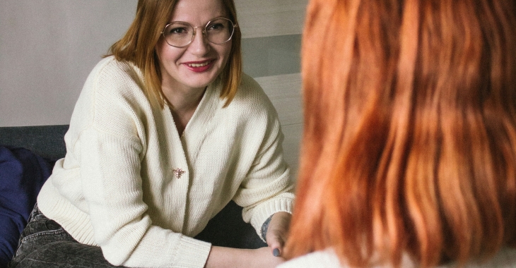 Twee personen voeren een persoonlijk gesprek in een rustige, huiselijke omgeving.