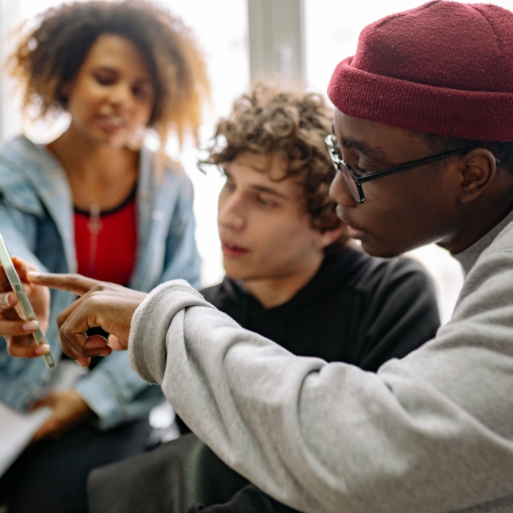 Jongeren kijken samen op smartphone.