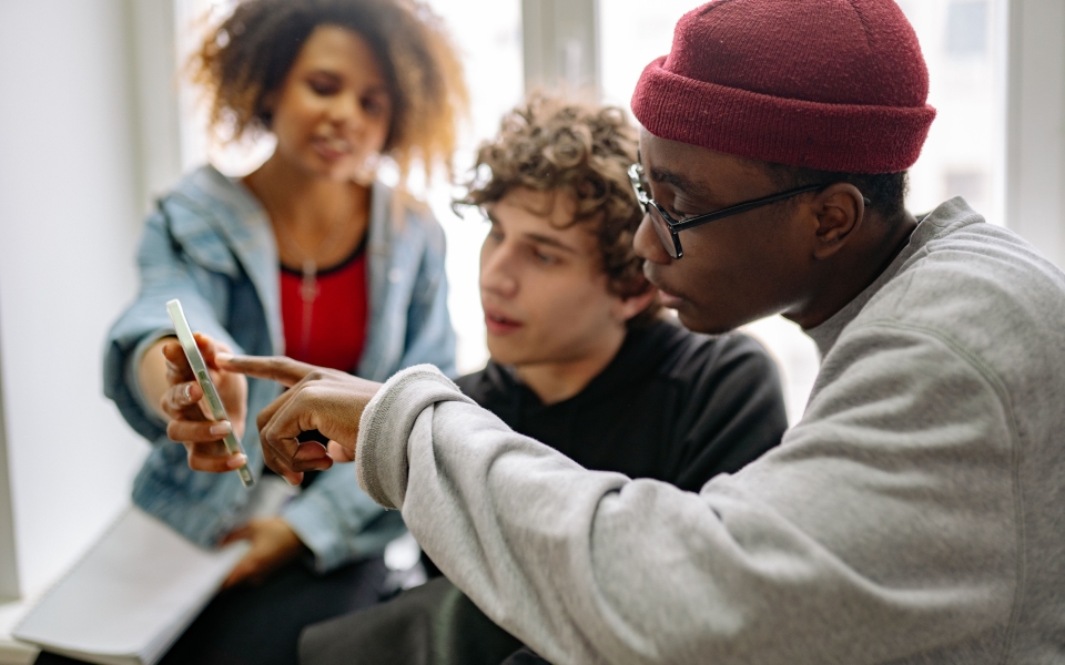 Jongeren kijken samen op smartphone.