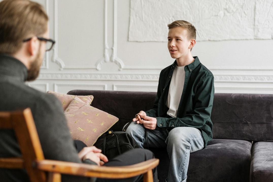 Jongere in counselinggesprek in een rustige binnenruimte