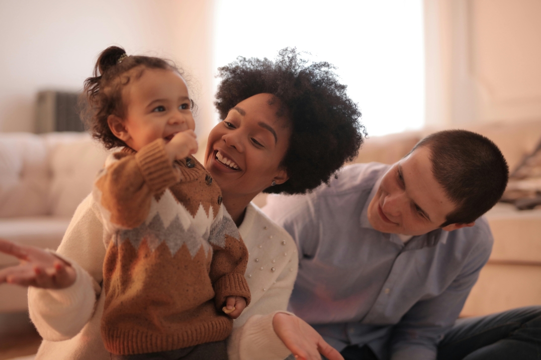 Twee ouders spelen met hun peuter.