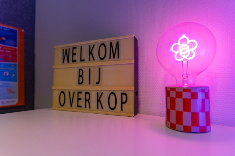 Lichtbak met tekst 'Welkom bij OverKop' en neonlamp met bloemetje